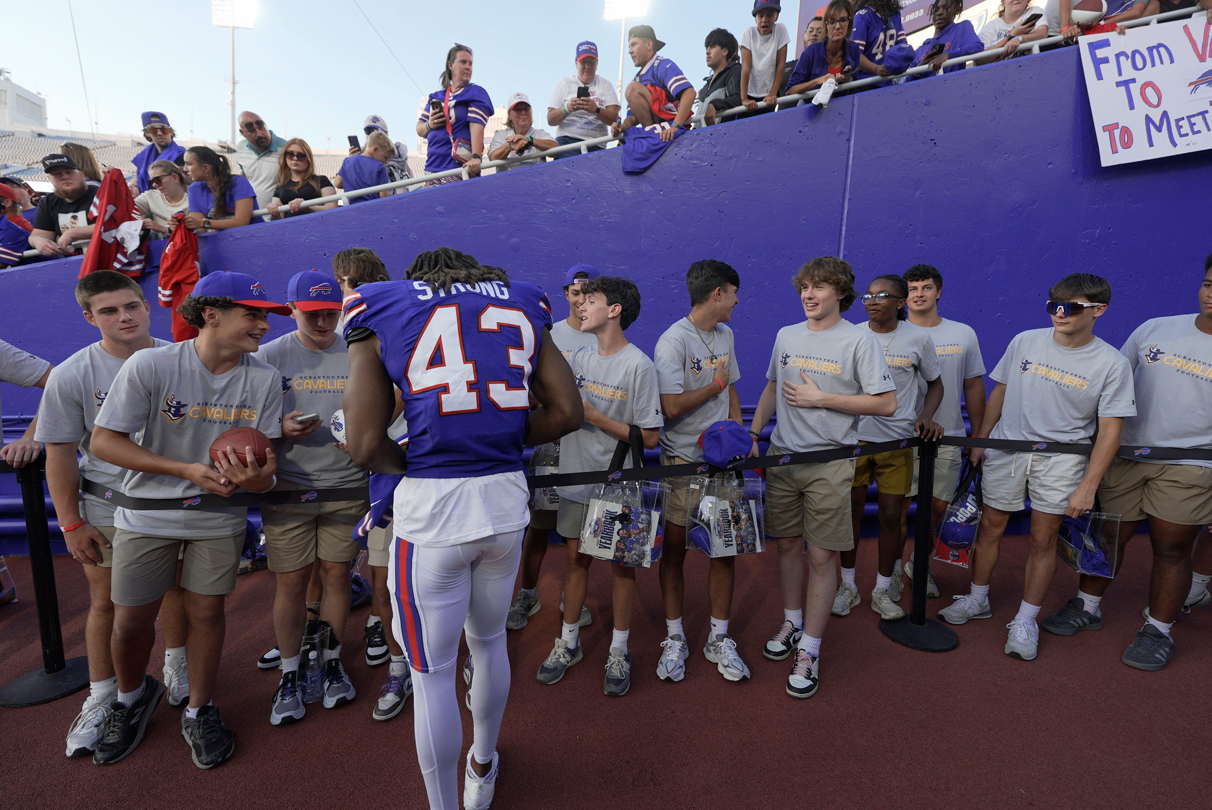 Buffalo Bills Dorian Strong stops to sign an autograph for a high school football player whose team was lined up in the tunnel to the field. Players signed autographs for fans and hung out with their family after the Return of the Blue & Red practice at Highmark Stadium in Orchard Park on Aug.1, 2025.