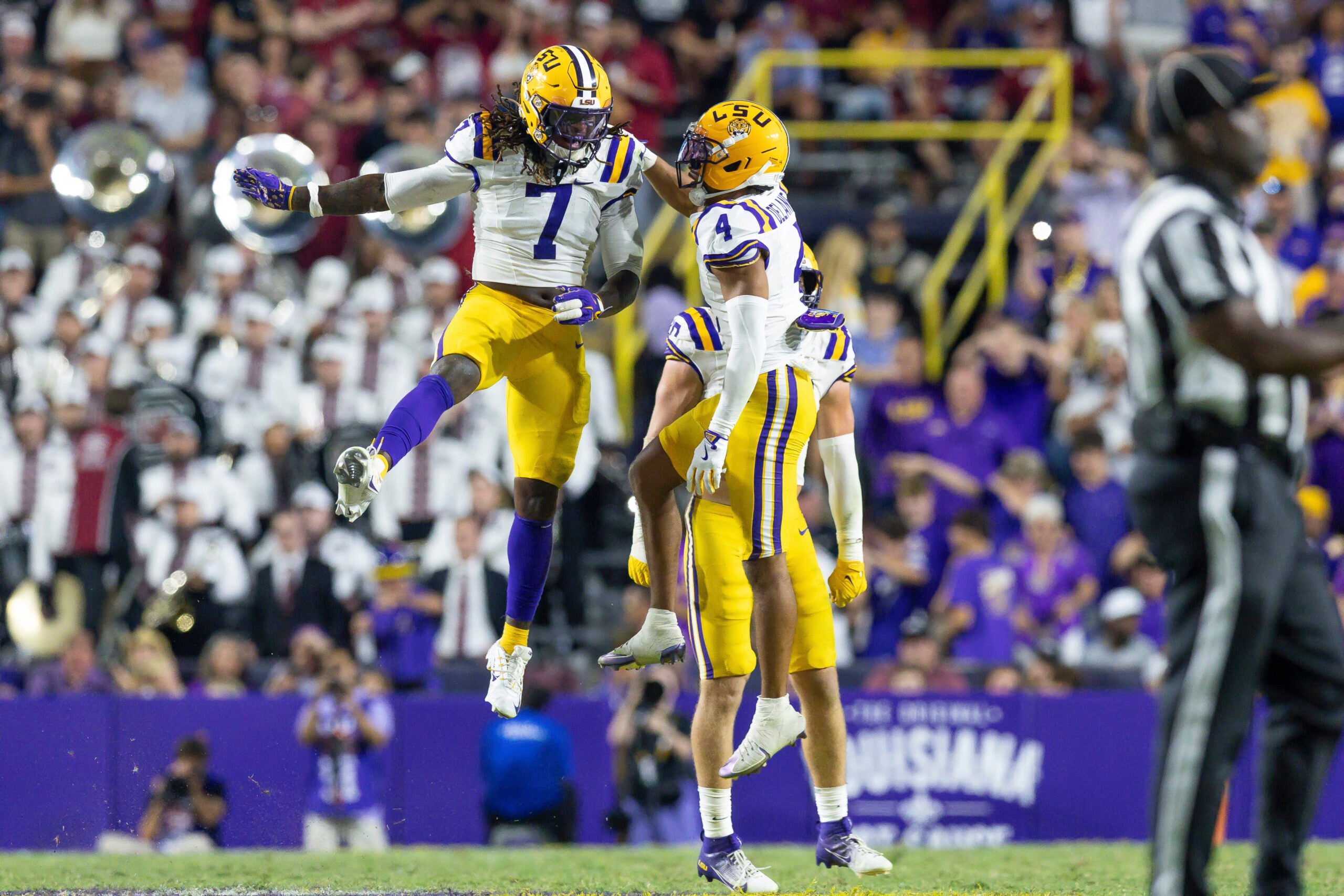 Oct 11, 2025; Baton Rouge, Louisiana, USA; LSU Tigers linebacker Harold Perkins Jr. (7) and cornerback Mansoor Delane (4) celebrate a turnover on downs during the second half at Tiger Stadium.