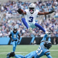 Oct 12, 2025; Charlotte, North Carolina, USA; Dallas Cowboys wide receiver George Pickens (3) jumps over Carolina Panthers safety Nick Scott (21) during the first quarter against the Carolina Panthers at Bank of America Stadium.