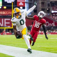 Oct 19, 2025; Glendale, Arizona, USA; Green Bay Packers wide receiver Matthew Golden (0) is pushed out of bounds by Arizona Cardinals cornerback Max Melton (16) in the second half at State Farm Stadium.