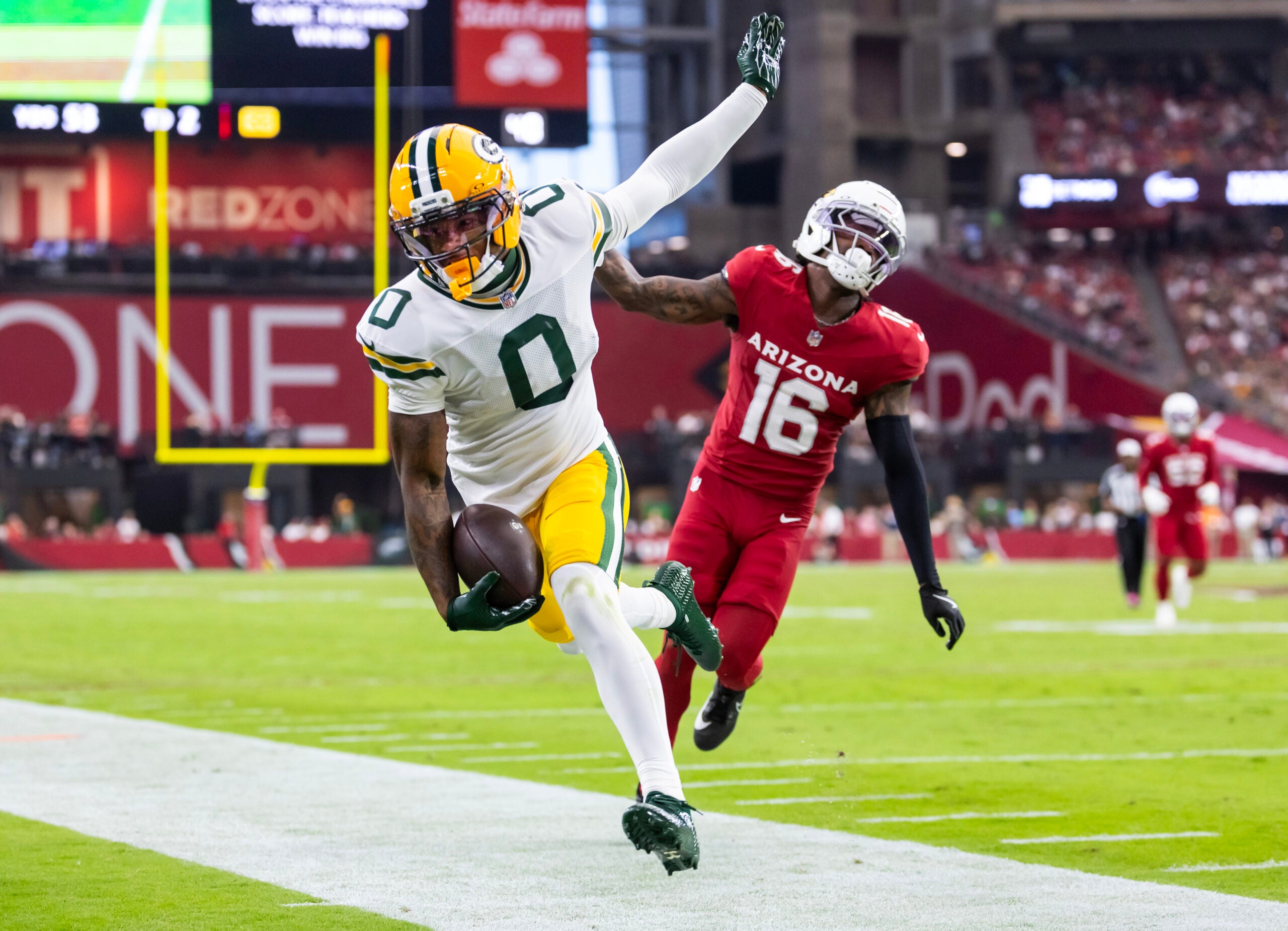 Oct 19, 2025; Glendale, Arizona, USA; Green Bay Packers wide receiver Matthew Golden (0) is pushed out of bounds by Arizona Cardinals cornerback Max Melton (16) in the second half at State Farm Stadium.
