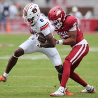Oct 25, 2025; Fayetteville, Arkansas, USA; Auburn Tigers wide receiver Cam Coleman (8) is tackled after a catch by Arkansas Razorbacks defensive back Julian Neal (23) during the first quarter at Donald W. Reynolds Razorback Stadium.