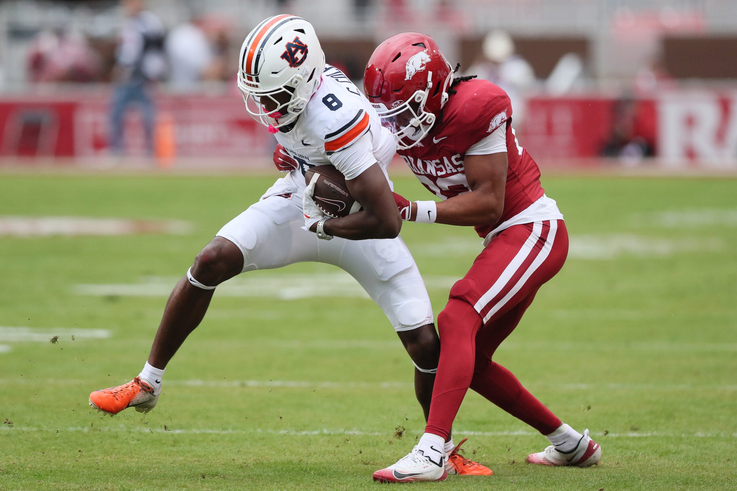 Oct 25, 2025; Fayetteville, Arkansas, USA; Auburn Tigers wide receiver Cam Coleman (8) is tackled after a catch by Arkansas Razorbacks defensive back Julian Neal (23) during the first quarter at Donald W. Reynolds Razorback Stadium.