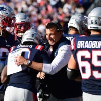 Patriots head coach Mike Vrabel celebrates with multiple players on the sideline
