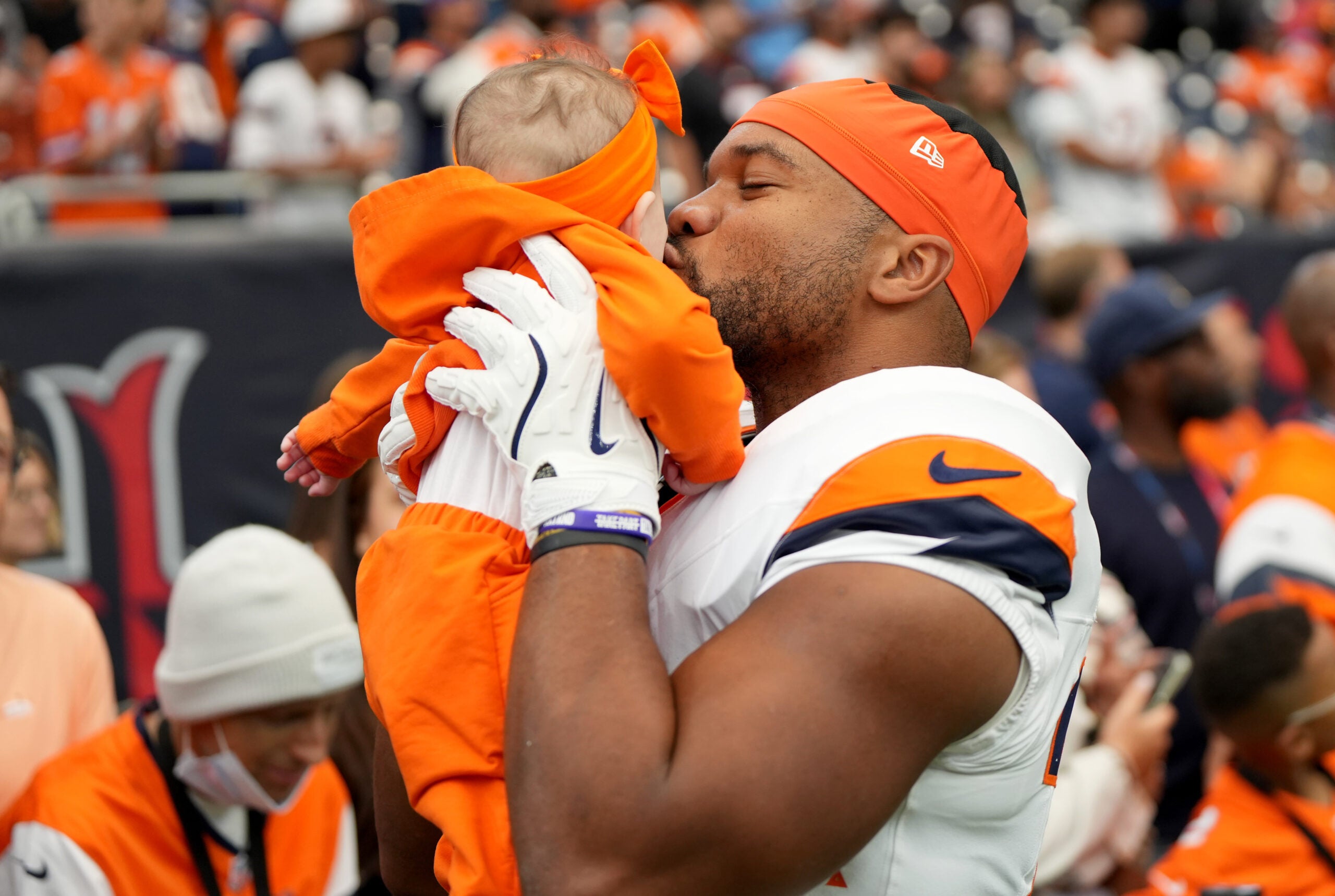 Nov 2, 2025; Houston, Texas, USA; Denver Broncos running back J.K. Dobbins (27) kisses a baby before a game against the Houston Texans at NRG Stadium.