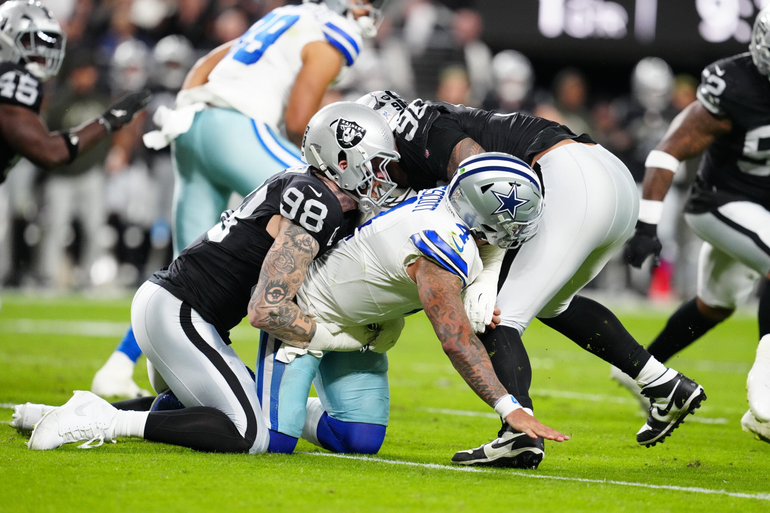 Nov 17, 2025; Paradise, Nevada, USA; Las Vegas Raiders defensive end Maxx Crosby (98) takes down Dallas Cowboys quarterback Dak Prescott (4) after forcing a fumble during the first half at Allegiant Stadium.
