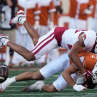 Nov 22, 2025; Austin, Texas, USA; Arkansas Razorbacks defensive back Julian Neal (23) hits Texas Longhorns wide receiver Emmett Mosley V (3) during the first half at Darrell K Royal-Texas Memorial Stadium.