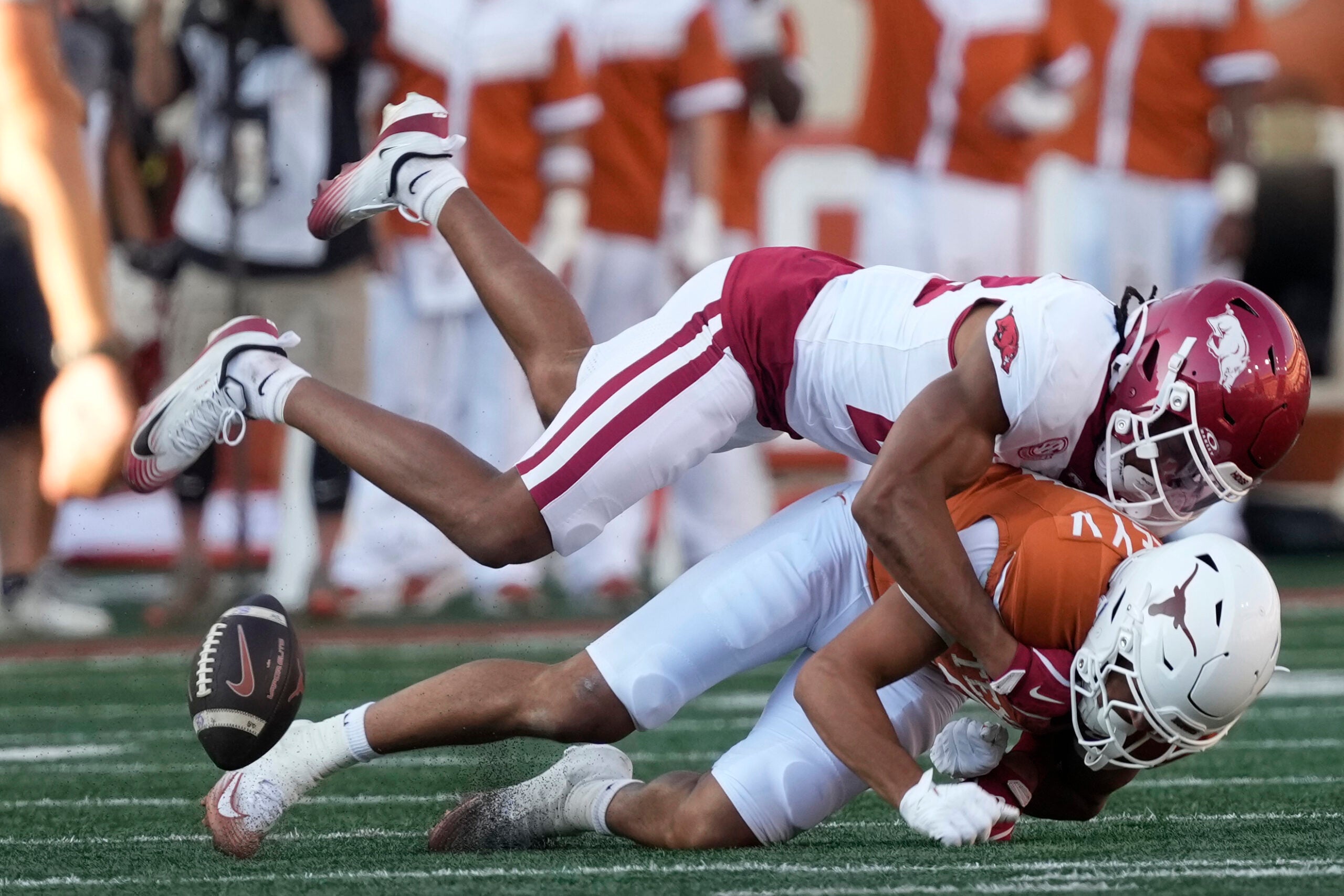Nov 22, 2025; Austin, Texas, USA; Arkansas Razorbacks defensive back Julian Neal (23) hits Texas Longhorns wide receiver Emmett Mosley V (3) during the first half at Darrell K Royal-Texas Memorial Stadium.