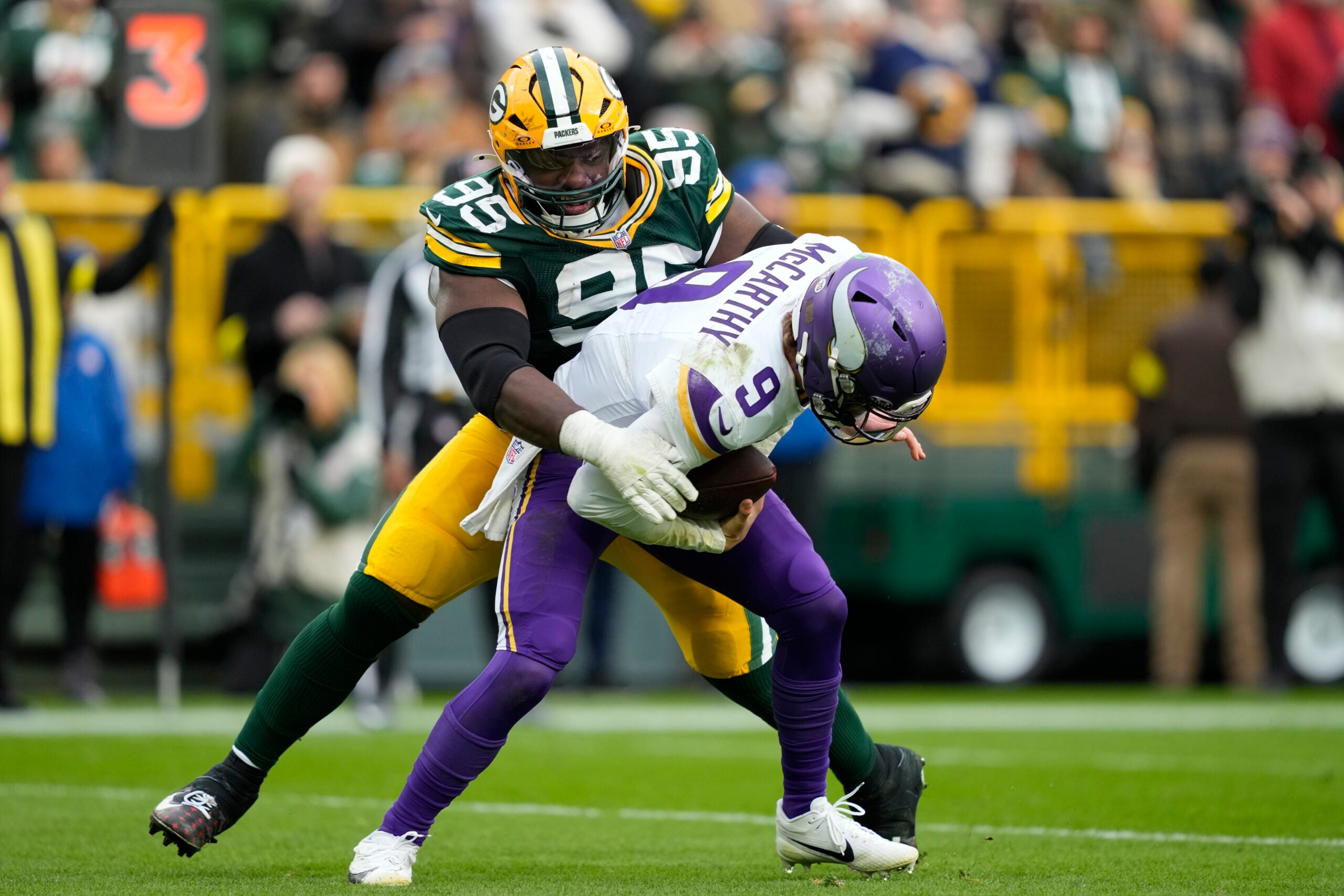 Nov 23, 2025; Green Bay, Wisconsin, USA; Minnesota Vikings quarterback J.J. McCarthy (9) is sacked by. Green Bay Packers defensive tackle Devonte Wyatt (95) during the second half at Lambeau Field.
