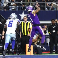 Dec 14, 2025; Arlington, Texas, USA; Minnesota Vikings wide receiver Jalen Nailor (1) makes a touchdown catch against Dallas Cowboys safety Donovan Wilson (6) during the second half at AT&T Stadium.