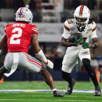 Dec 31, 2025; Arlington, TX, USA; Miami Hurricanes linebacker Raul Aguirre Jr. (10) moves with the ball while defended by Ohio State Buckeyes safety Caleb Downs (2) in the first quarter during the 2025 Cotton Bowl and quarterfinal game of the College Football Playoff at AT&T Stadium.