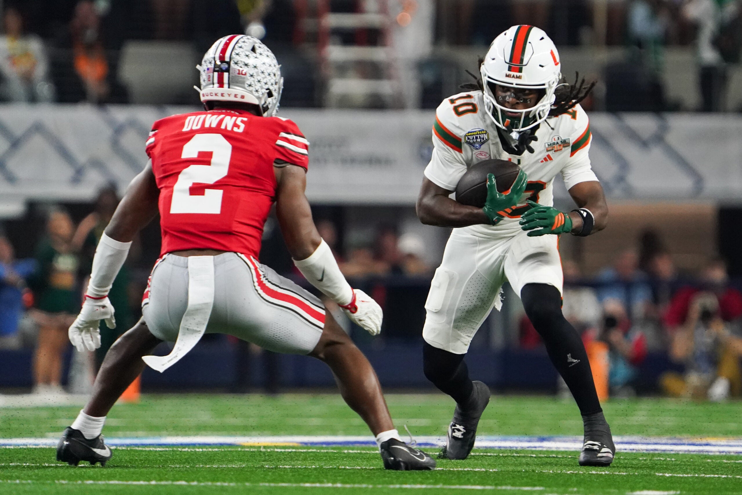 Dec 31, 2025; Arlington, TX, USA; Miami Hurricanes linebacker Raul Aguirre Jr. (10) moves with the ball while defended by Ohio State Buckeyes safety Caleb Downs (2) in the first quarter during the 2025 Cotton Bowl and quarterfinal game of the College Football Playoff at AT&T Stadium.