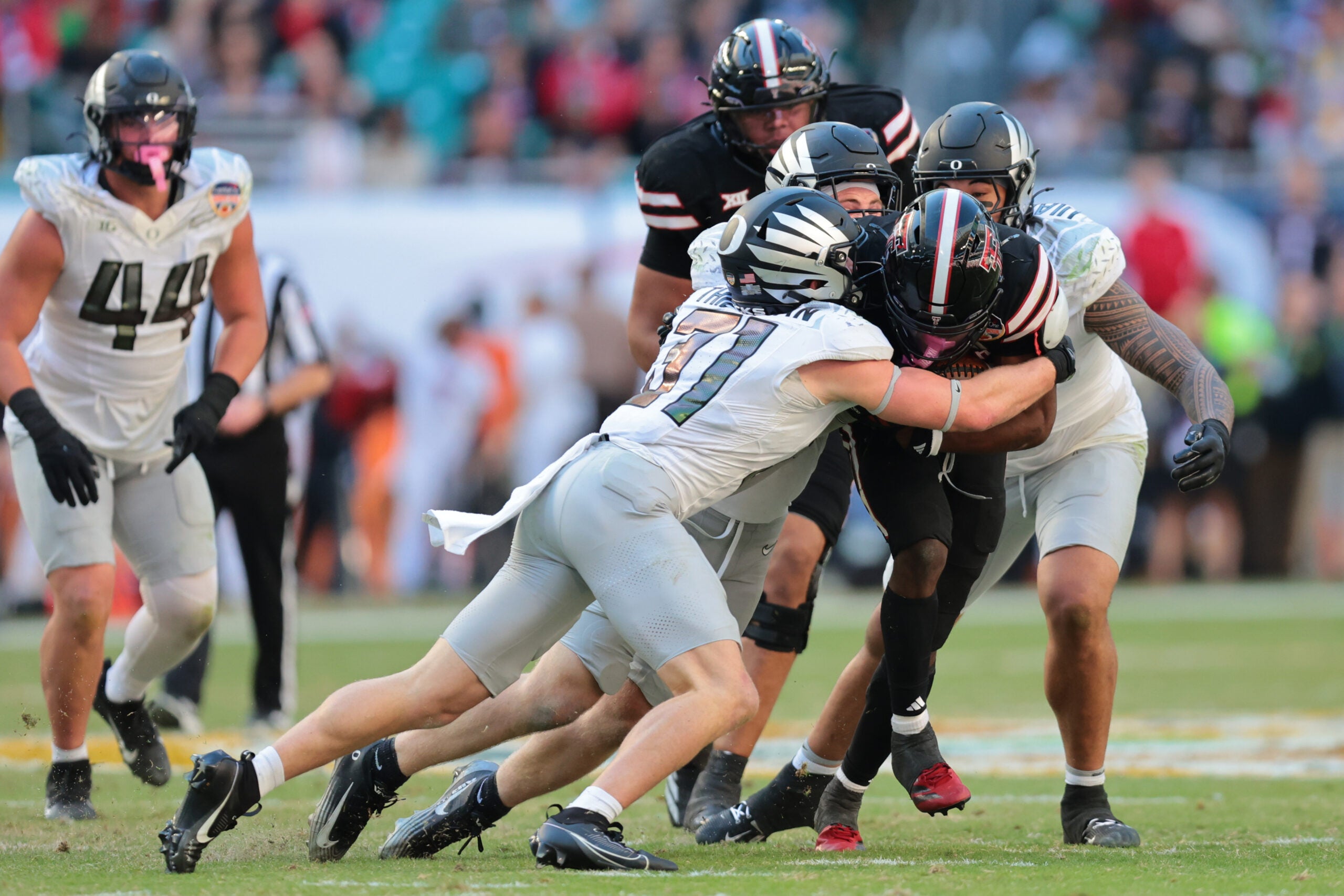 Jan 1, 2026; Miami Gardens, FL, USA; Texas Tech Red Raiders running back J'Koby Williams (20) is tackled by Oregon Ducks defensive back Dillon Thieneman (31) during the second half of the 2025 Orange Bowl and quarterfinal game of the College Football Playoff at Hard Rock Stadium.