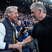 Nate Forbes, left, talks to football head coach Kyle Whittingham after him being introduced on the court during the first half between Michigan and USC at Crisler Center in Ann Arbor on Friday, Jan. 2, 2026.
