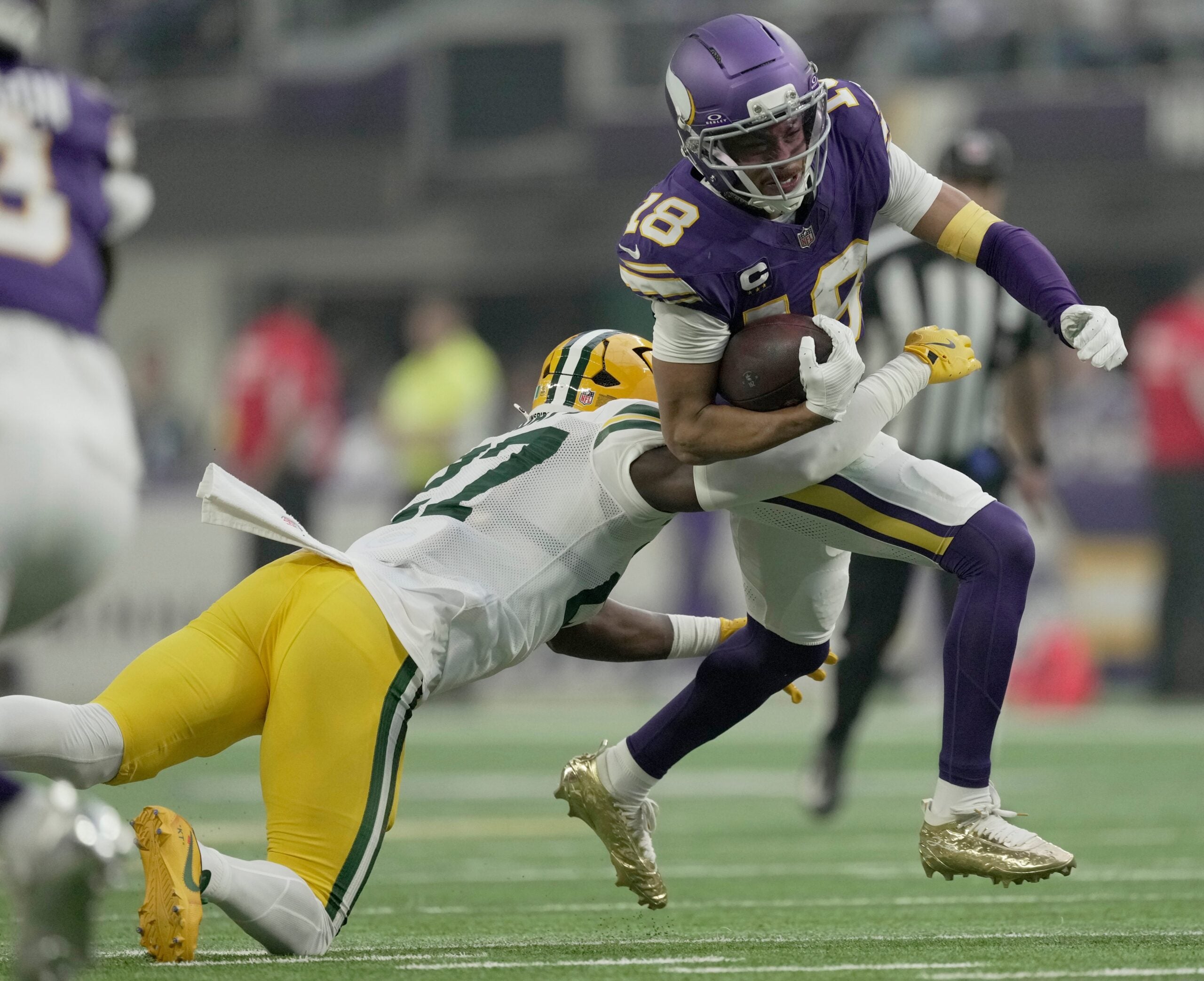 Minnesota Vikings wide receiver Justin Jefferson (18) is tackled by Green Bay Packers safety Kitan Oladapo (27) during the first quarter of their game Sunday, January 4, 2026 at U.S. Bank Stadium in Minneapolis, Minnesota.