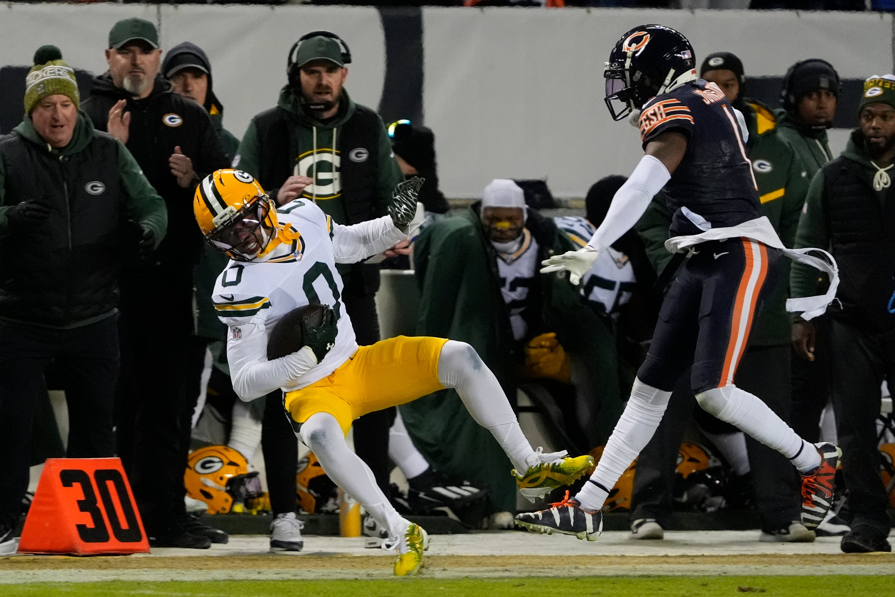 Jan 10, 2026; Chicago, IL, USA; Green Bay Packers wide receiver Matthew Golden (0) is pushed down by Chicago Bears cornerback Jaylon Johnson (1) during the first half of an NFC Wild Card Round game at Soldier Field.