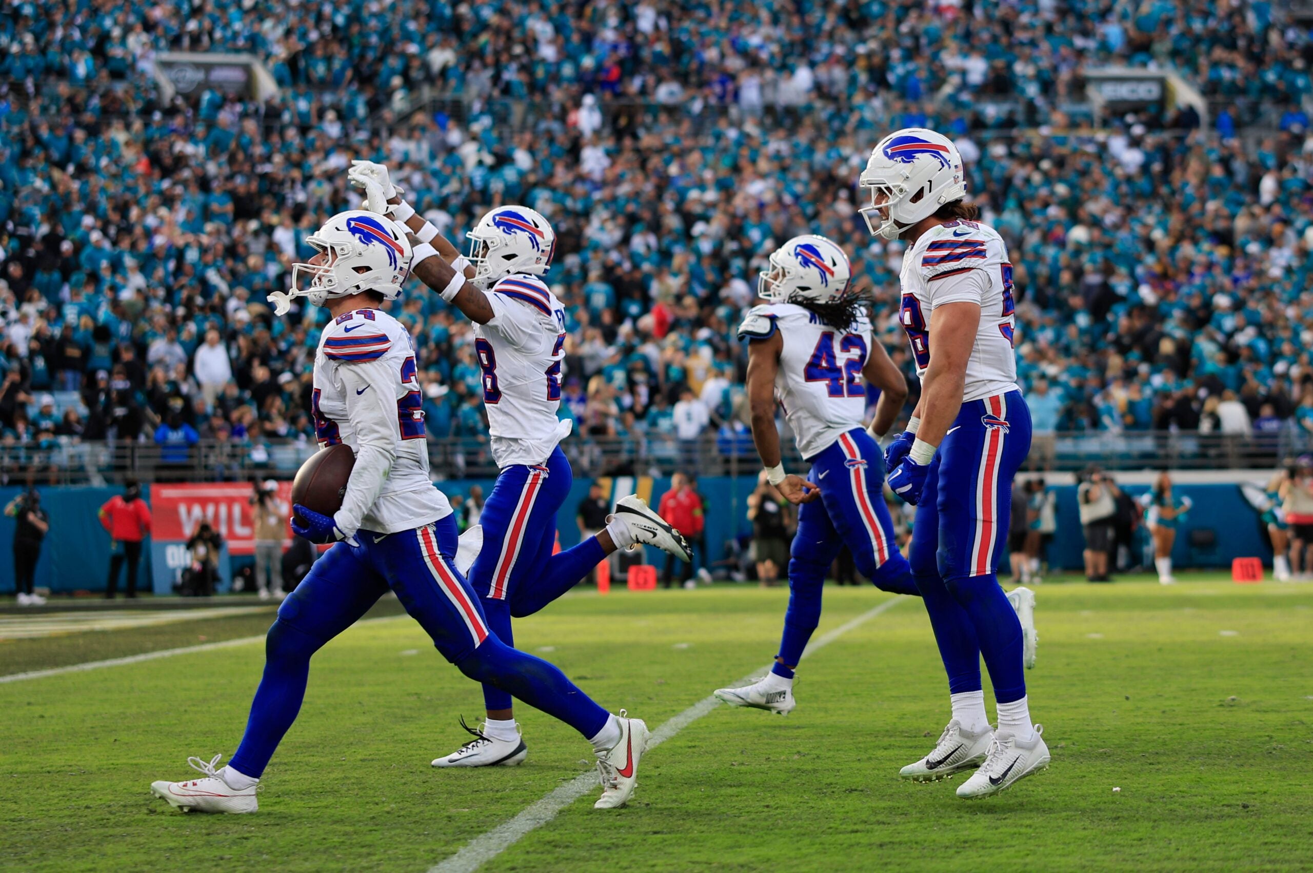 Buffalo Bills safety Cole Bishop (24), from left, celebrates his interception, sealing the game, with safety Sam Franklin Jr. (28), linebacker Dorian Williams (42) and linebacker Matt Milano (58), during the fourth quarter of an NFL football AFC Wild Card playoff matchup, Sunday, Jan. 11, 2026, in Jacksonville, Fla. The Bills defeated the Jaguars 27-24.