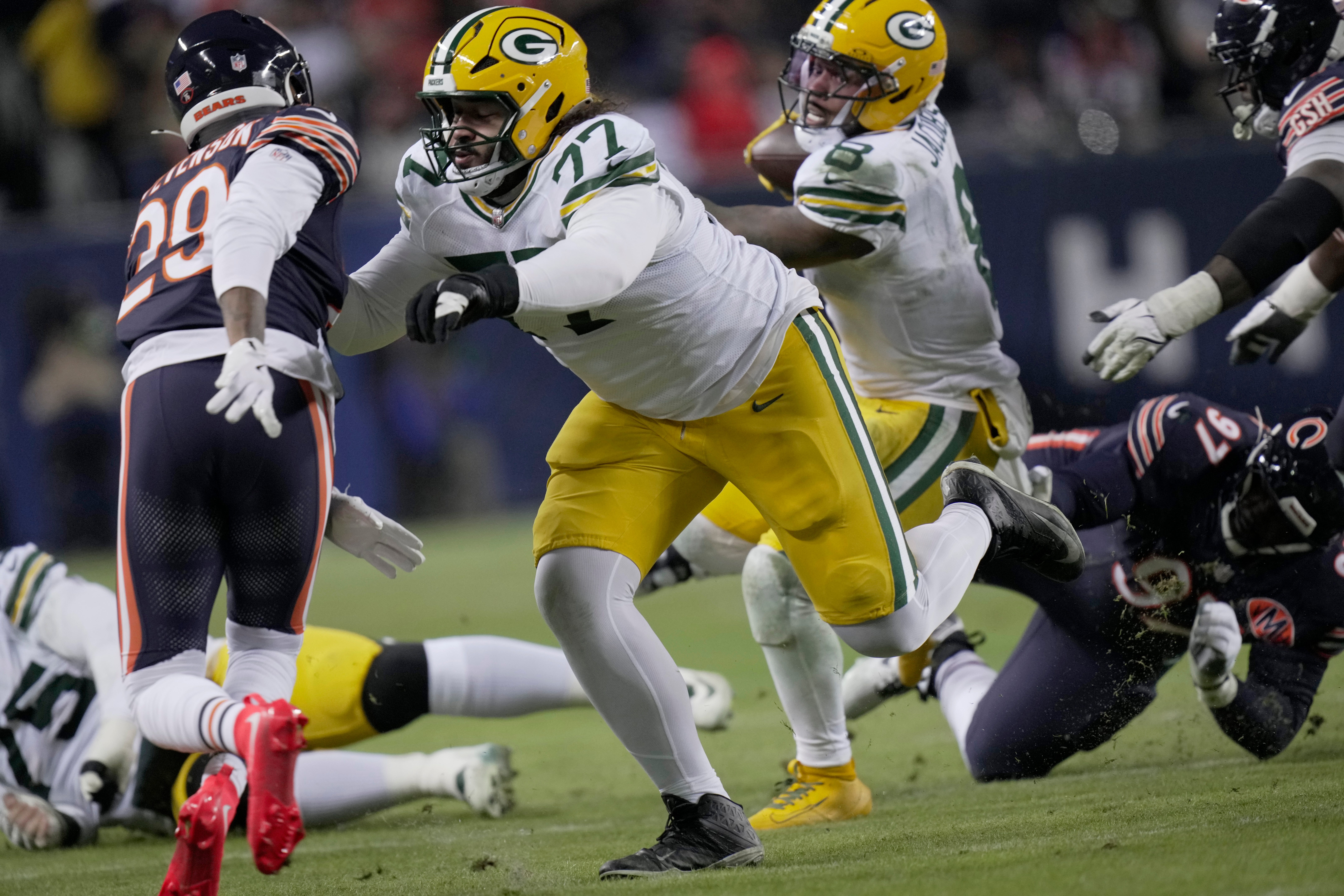 Green Bay Packers guard Jordan Morgan (77) clears the way for running back Josh Jacobs (8) during the second quarter of their wild card playoff game against the Chicago Bears Saturday, January 10, 2026 at Soldier Field in Chicago, Illinois.