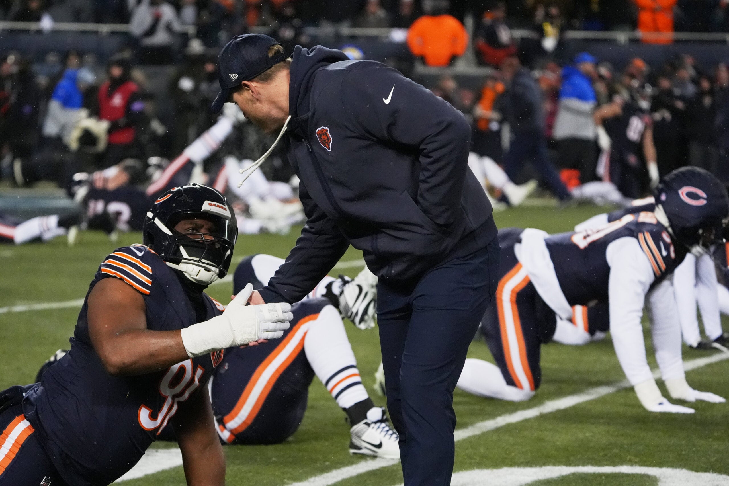 Jan 18, 2026; Chicago, IL, USA; Chicago Bears head coach Ben Johnson shakes hands with defensive lineman Chris Williams (91) during warmups before an NFC Divisional Round game against the Los Angeles Rams at Soldier Field.