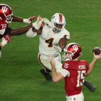 Jan 19, 2026; Miami Gardens, FL, USA; Indiana Hoosiers quarterback Fernando Mendoza (15) passes the ball under pressure by Miami Hurricanes defensive lineman Rueben Bain Jr. (4) in the third quarter during the College Football Playoff National Championship game at Hard Rock Stadium. Mandatory Credit: Kim Klement Neitzel-Imagn Images