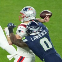 Feb 8, 2026; Santa Clara, CA, USA; New England Patriots quarterback Drake Maye (10) is hit as he throws by Seattle Seahawks defensive end DeMarcus Lawrence (0) in the second half in Super Bowl LX at Levi's Stadium.