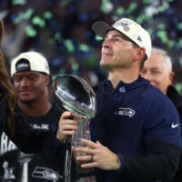 Feb 8, 2026; Santa Clara, CA, USA; Seattle Seahawks head coach Mike MacDonald celebrates with the Vince Lombardi trophy on the podium after defeating the New England Patriots in Super Bowl LX at Levi's Stadium.