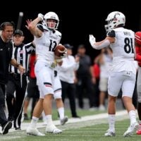 Cincinnati Bearcats head coach Luke Fickell, left, encourages Cincinnati Bearcats wide receiver Alec Pierce (12) after a reception for a first down in the first quarter of a college football game against the Ohio State Buckeyes, Saturday, Sept. 7, 2019, at Ohio Stadium in Columbus.