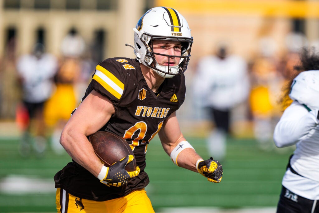 Nov 18, 2023; Laramie, Wyoming, USA; Wyoming Cowboys tight end John Michael Gyllenborg (84) scores a touchdown against the Hawaii Rainbow Warriors during the first quarter at Jonah Field at War Memorial Stadium.