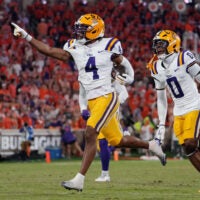 Aug 30, 2025; Clemson, South Carolina, USA; LSU Tigers cornerback Mansoor Delane (4) celebrates with safety Tamarcus Cooley (0) after a play against the Clemson Tigers during the second half at Memorial Stadium.
