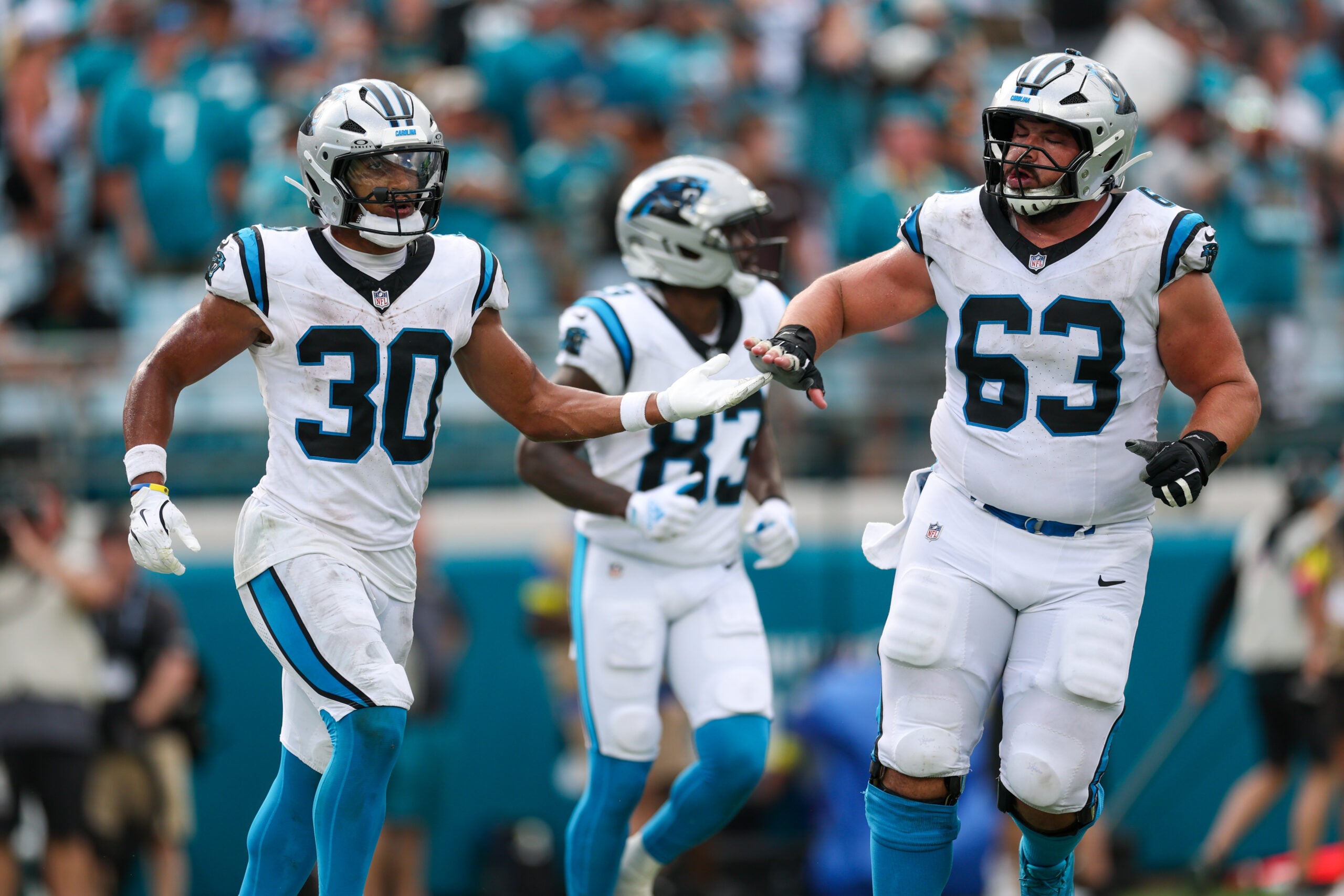 Sep 7, 2025; Jacksonville, Florida, USA; Carolina Panthers running back Chuba Hubbard (30) and center Austin Corbett (63) celebrate a touchdown against the Jacksonville Jaguars during the second half at EverBank Stadium.