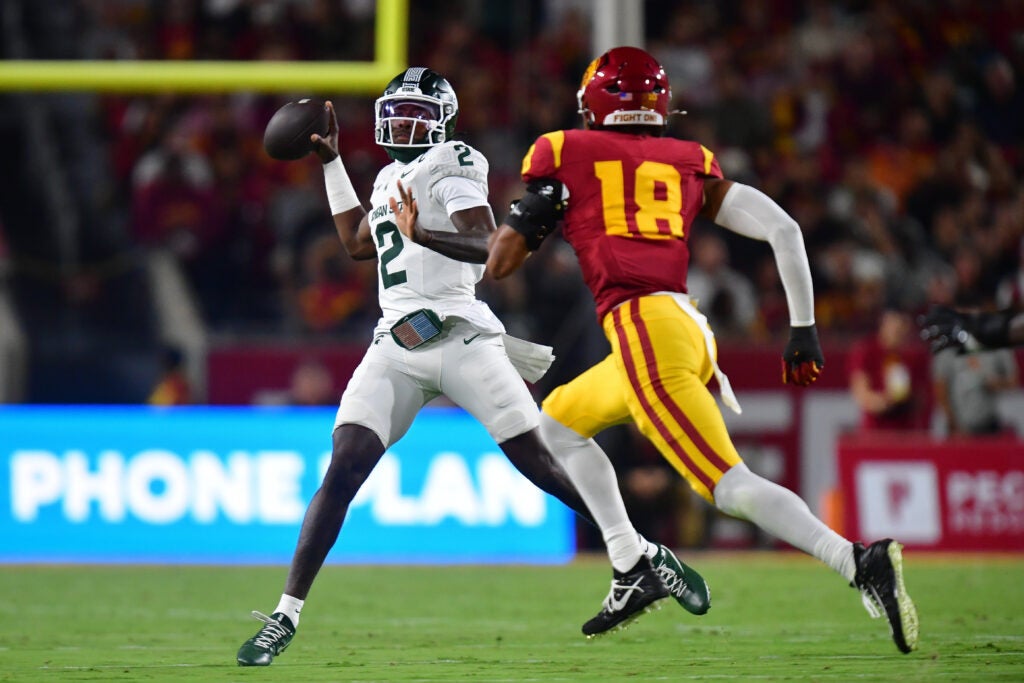 Sep 20, 2025; Los Angeles, California, USA; Michigan State Spartans quarterback Aidan Chiles (2) throws under pressure from Southern California Trojans linebacker Eric Gentry (18) during the first half at the Los Angeles Memorial Coliseum. 