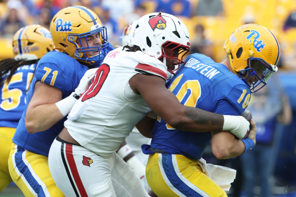 Sep 27, 2025; Pittsburgh, Pennsylvania, USA; Louisville Cardinals defensive lineman Rene Konga (90) sacks Pittsburgh Panthers quarterback Eli Holstein (10) during the fourth quarter at Acrisure Stadium.