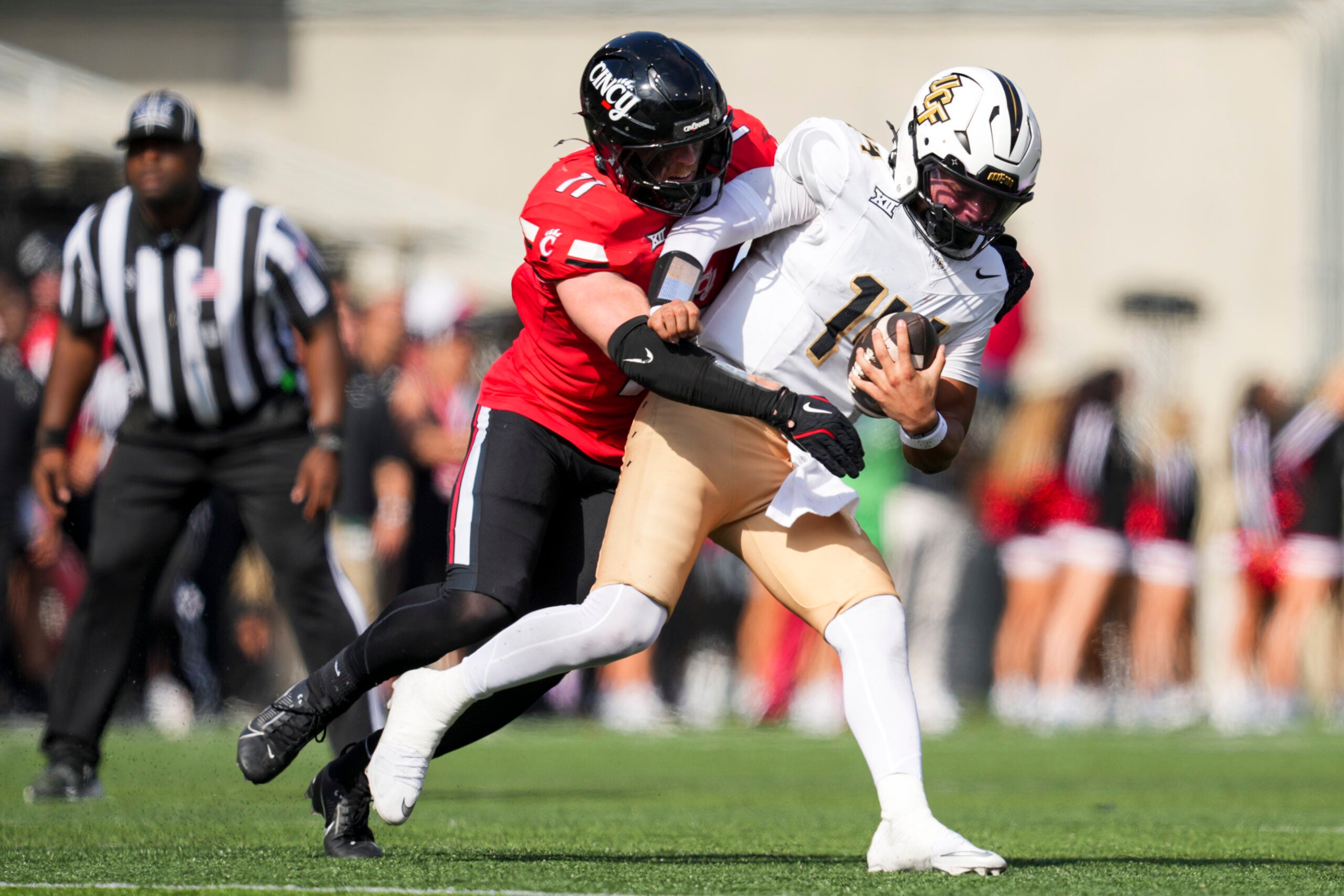 Oct 11, 2025; Cincinnati, Ohio, USA; Cincinnati Bearcats linebacker Jake Golday (11) attempts to tackle UCF Knights quarterback Cam Fancher (14) in the second half at Nippert Stadium.