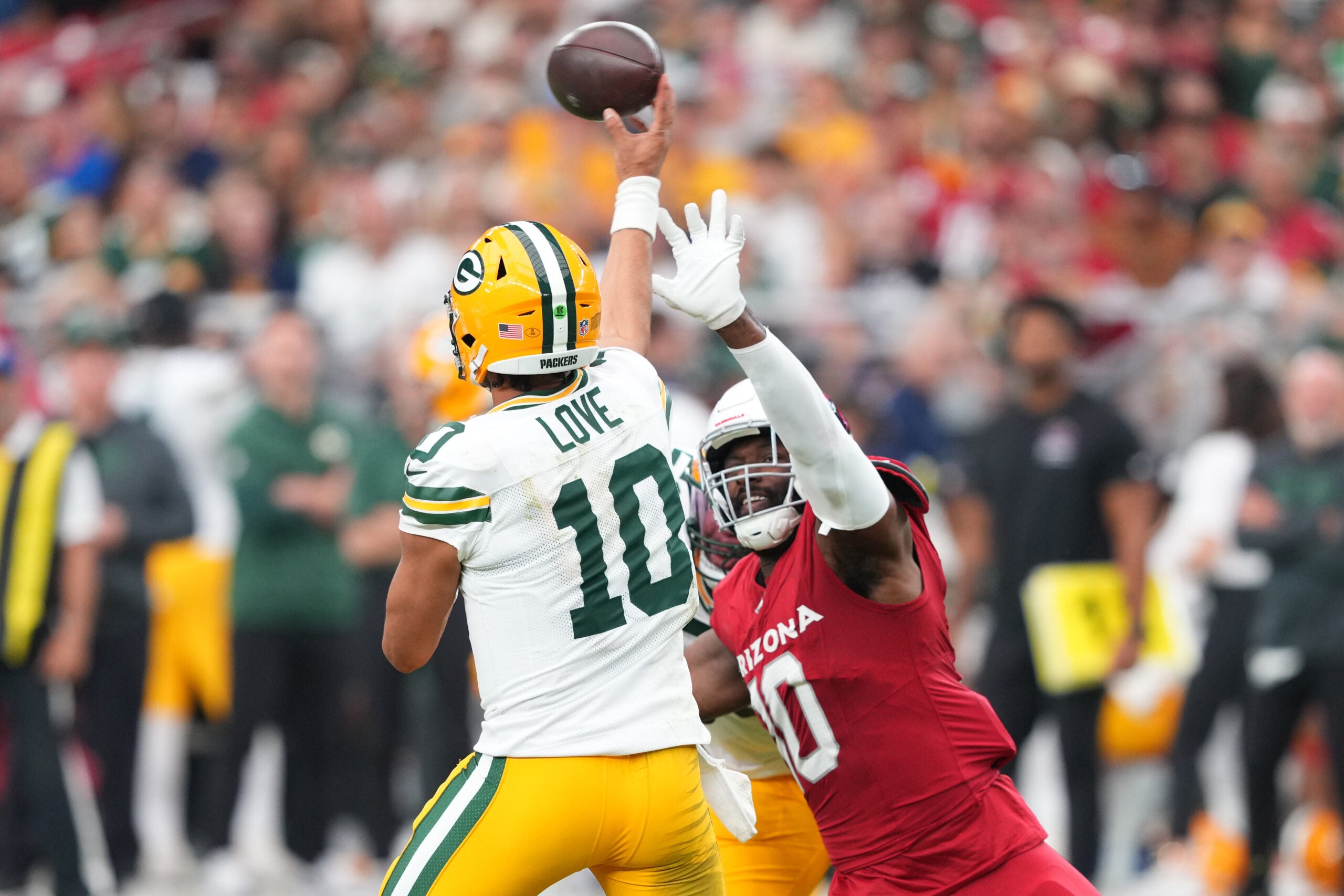 Oct 19, 2025; Glendale, Arizona, USA; Green Bay Packers quarterback Jordan Love (10) passes while being rushed by Arizona Cardinals outside linebacker Josh Sweat (10) during the second half at State Farm Stadium.