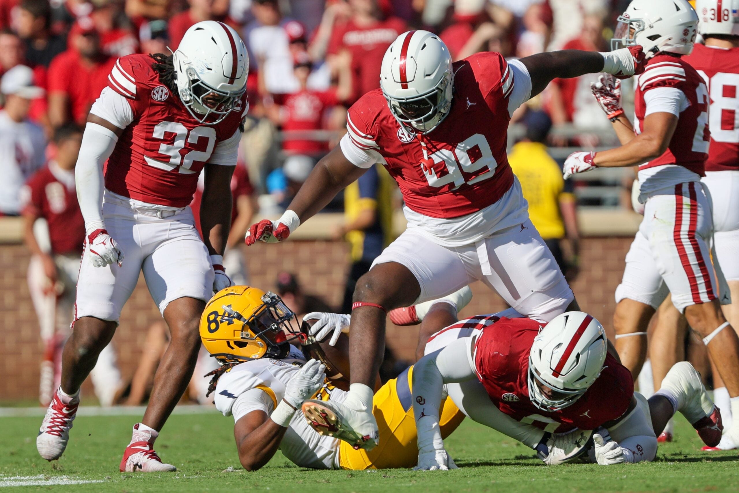 Oklahoma defensive linemen R Mason Thomas (32), Markus Strong (99) and David Stone, lower right, react to stopping Kent State running back Jahzae Kimbrough (84) during the first half of an NCAA football game between the Oklahoma Sooners (OU) and Kent State Golden Flashes at Gaylord Family - Oklahoma Memorial Stadium in Norman, Okla., Saturday, Oct. 4, 2025.