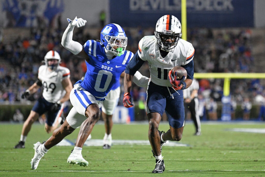 Nov 15, 2025; Durham, North Carolina, USA; Duke Blue Devils cornerback Chandler Rivers (0) attempts to swat the ball from Virginia Cavaliers wide receiver Trell Harris (11) during the third quarter at Wallace Wade Stadium.