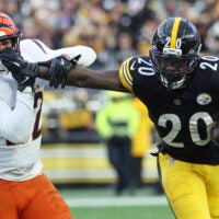 Nov 16, 2025; Pittsburgh, Pennsylvania, USA; Pittsburgh Steelers running back Kaleb Johnson (20) stiff arms Cincinnati Bengals safety Geno Stone (22) during the second half at Acrisure Stadium.