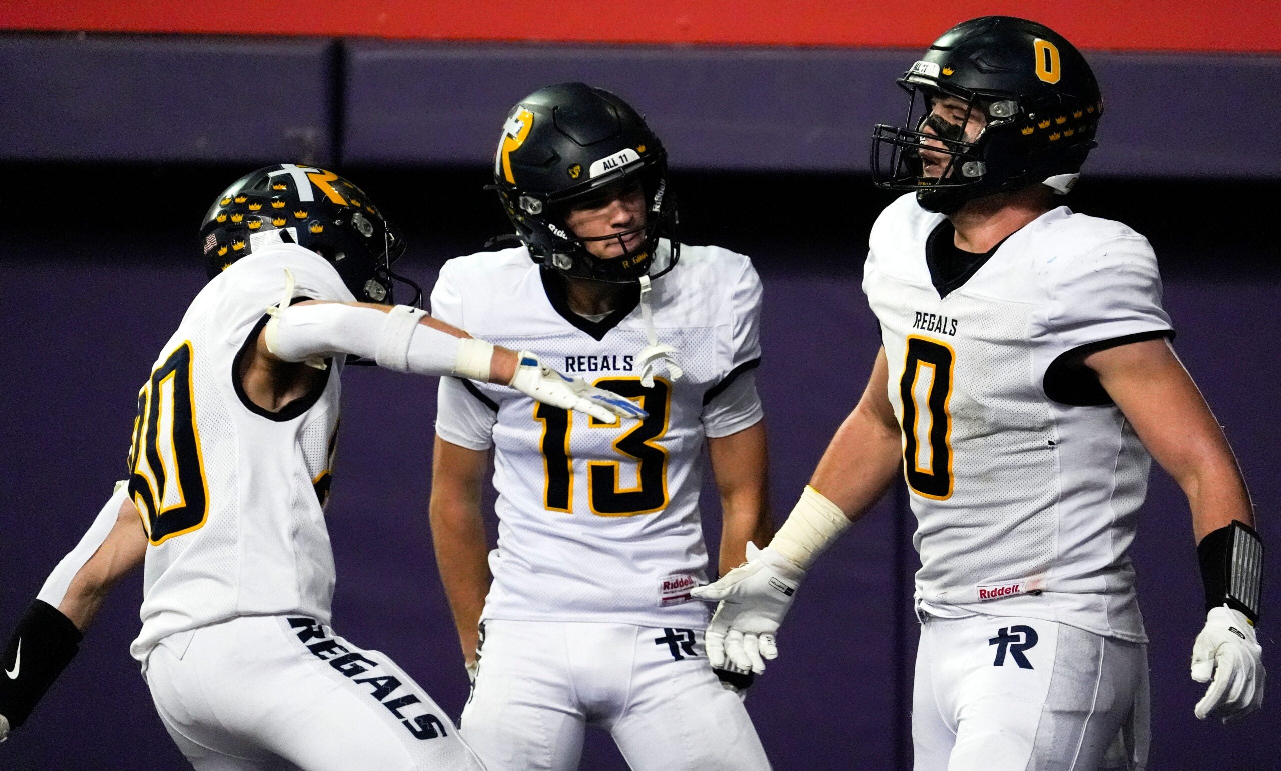 Iowa City Regina’s Tate Wallace (0) celebrates with teammates after scoring a touchdown Nov. 20, 2025 during the Class 1A state football championship against the West Lyon Wildcats at the UNI-Dome in Cedar Falls, Iowa.