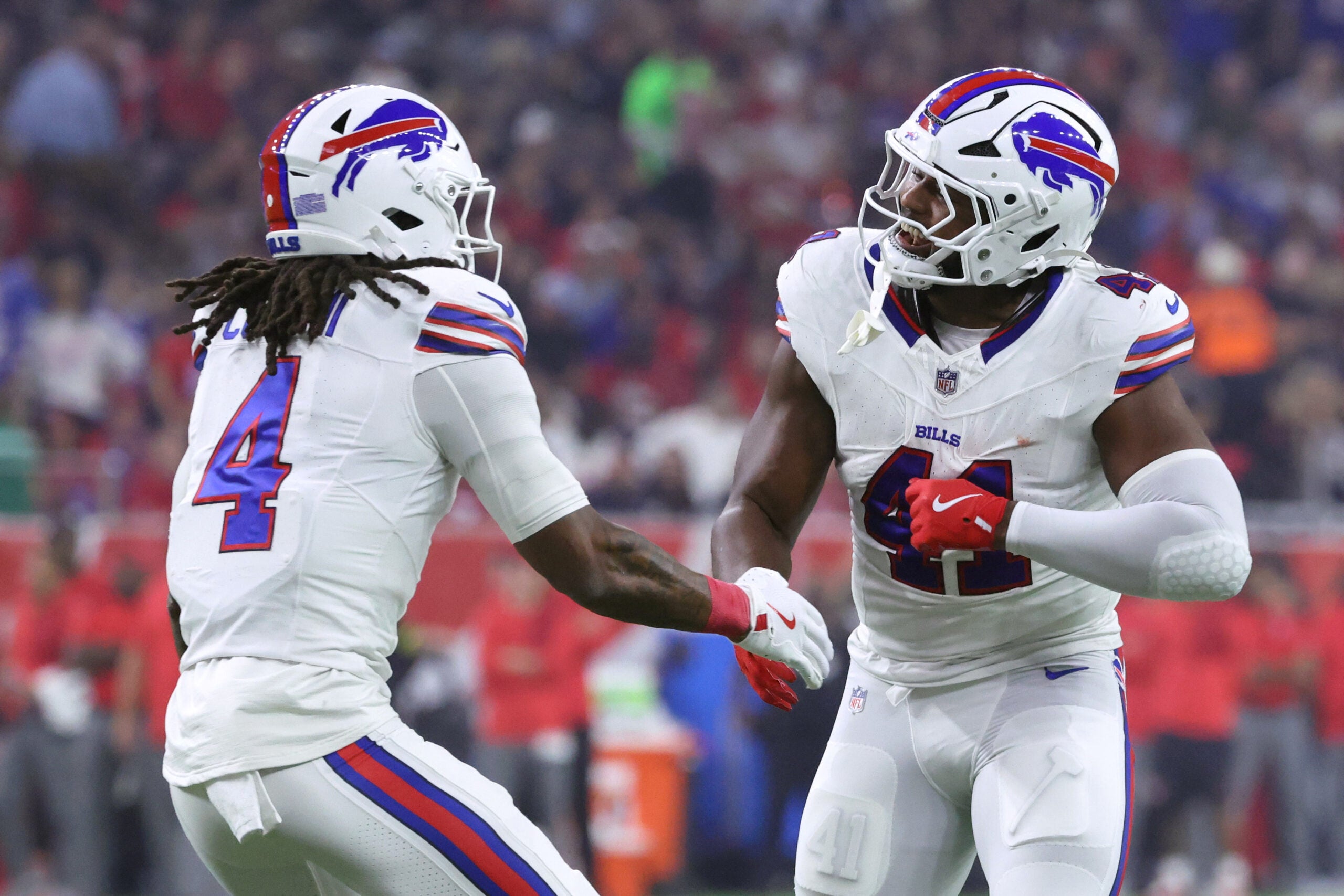 Nov 20, 2025; Houston, Texas, USA; Buffalo Bills running back James Cook III (4) celebrates with fullback Reggie Gilliam (41) after scoring a touchdown against the Houston Texans in the first quarter at NRG Stadium.