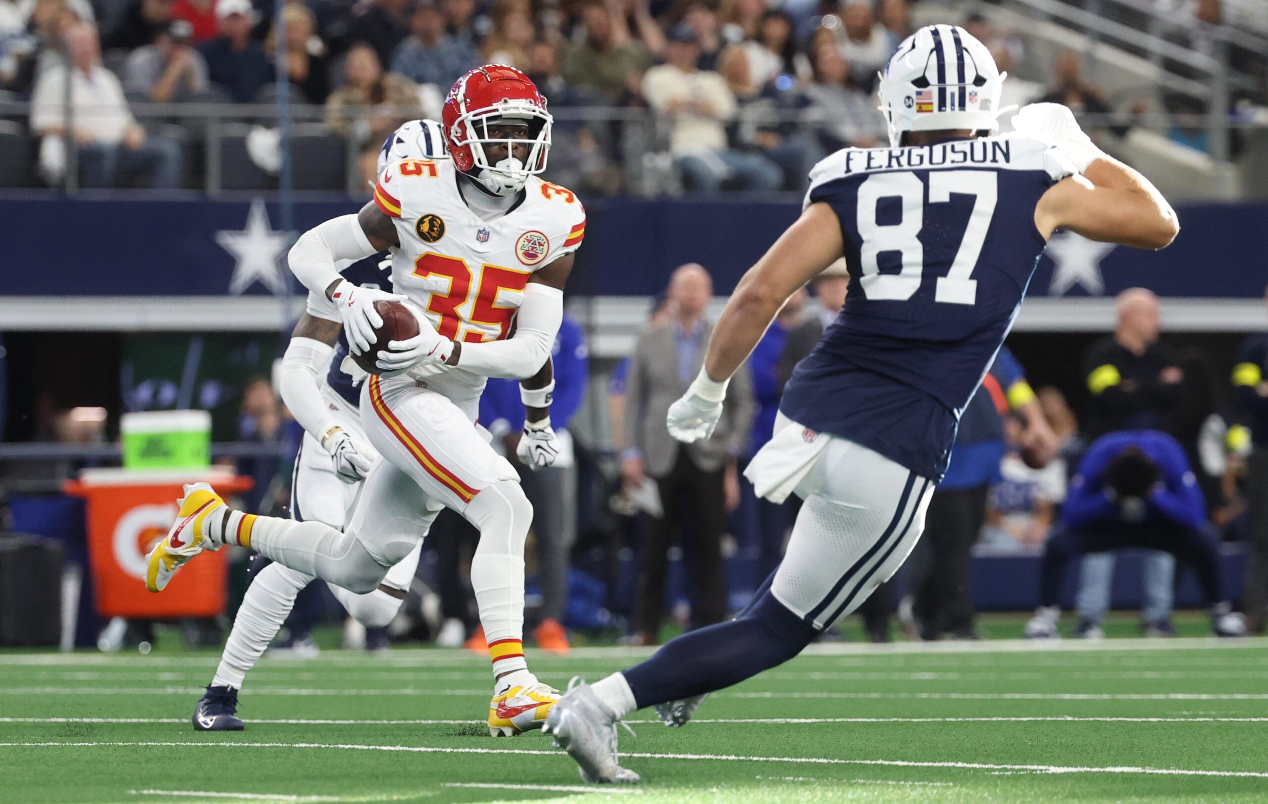 Nov 27, 2025; Arlington, Texas, USA; Kansas City Chiefs cornerback Jaylen Watson (35) returns an interception against Dallas Cowboys tight end Jake Ferguson (87) at AT&T Stadium.