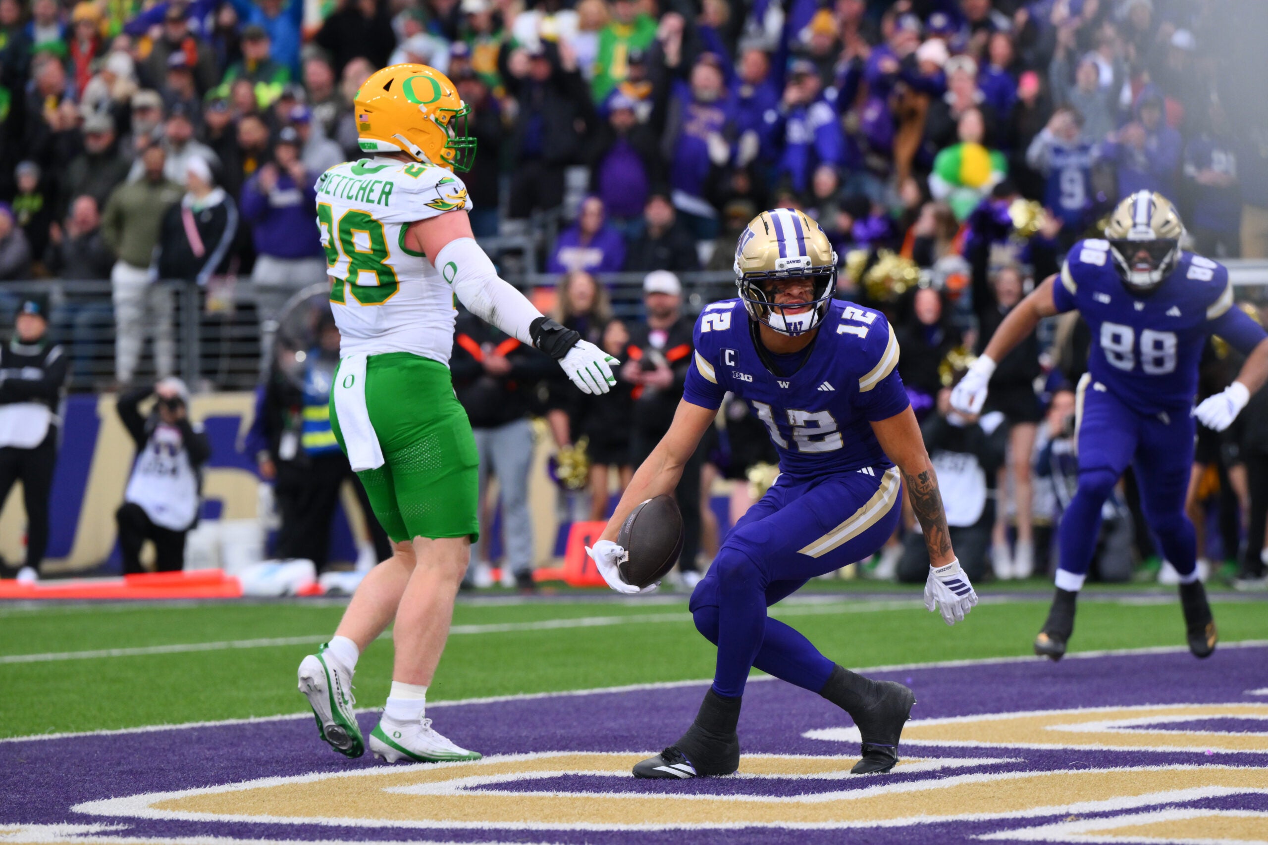 Nov 29, 2025; Seattle, Washington, USA; Washington Huskies wide receiver Denzel Boston (12) celebrates after scoring a touchdown against the Oregon Ducks during the first half at Husky Stadium. Mandatory Credit: Steven Bisig-Imagn Images