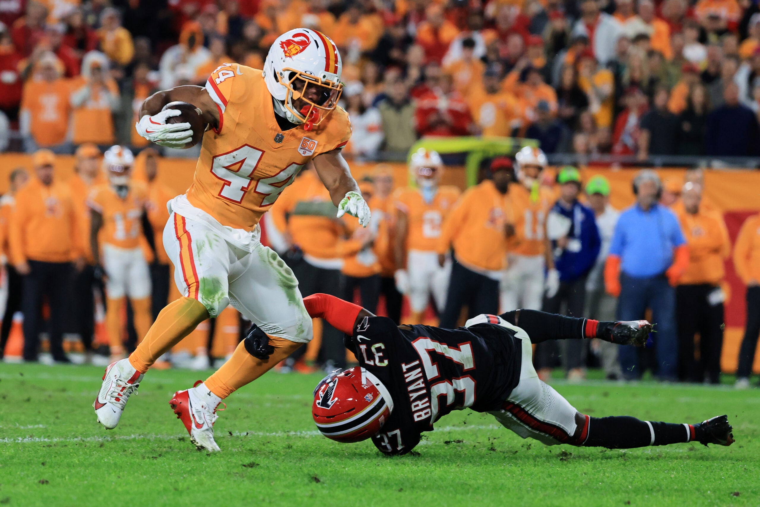 Dec 11, 2025; Tampa, Florida, USA; Tampa Bay Buccaneers running back Sean Tucker (44) breaks a tackle against Atlanta Falcons cornerback Cobee Bryant (37) during the third quarter at Raymond James Stadium.