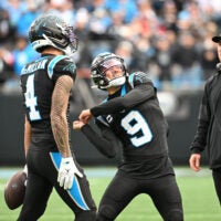 Dec 21, 2025; Charlotte, North Carolina, USA; Carolina Panthers wide receiver Tetairoa McMillan (4) throws an imaginary ball that quarterback Bryce Young (9) hits into the crowd after scoring a touchdown in the second quarter at Bank of America Stadium.