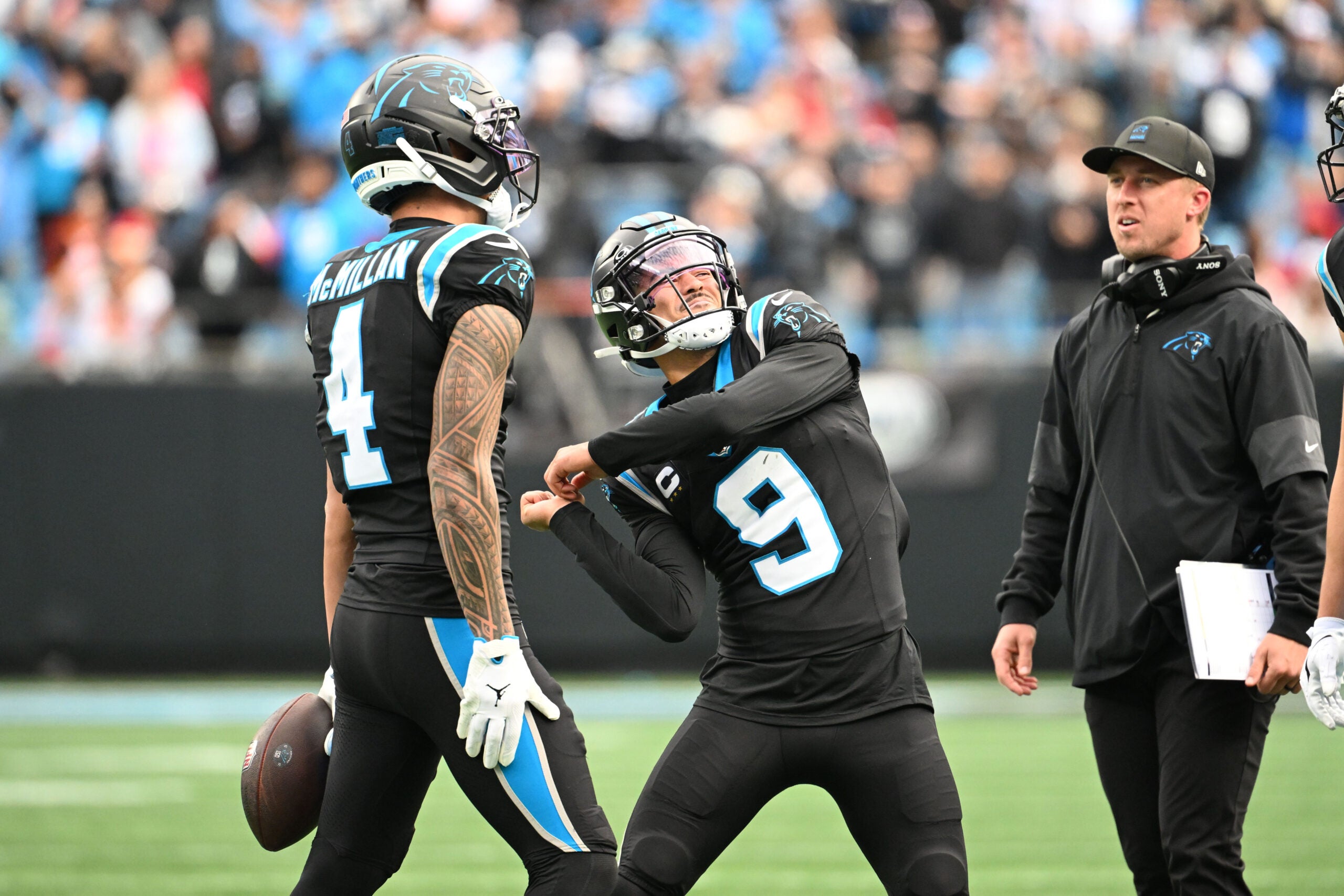 Dec 21, 2025; Charlotte, North Carolina, USA; Carolina Panthers wide receiver Tetairoa McMillan (4) throws an imaginary ball that quarterback Bryce Young (9) hits into the crowd after scoring a touchdown in the second quarter at Bank of America Stadium.