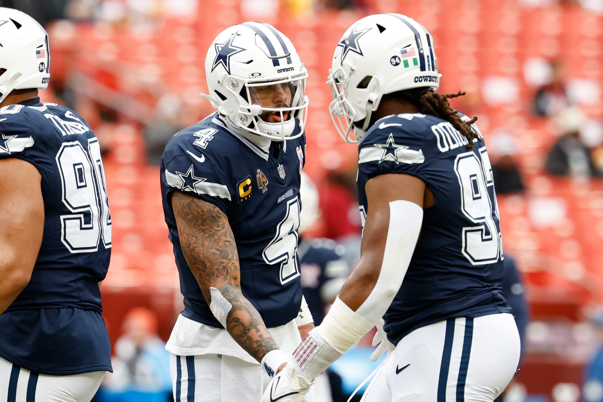 Dec 25, 2025; Landover, Maryland, USA; Dallas Cowboys quarterback Dak Prescott (4) greets defensive tackle Osa Odighizuwa (97) during warmups before the game against the Washington Commanders at Northwest Stadium.