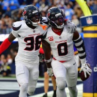 Dec 27, 2025; Inglewood, California, USA; Houston Texans linebacker Azeez al-Shaair (0) reacts with safety K'Von Wallace (38) after making an interception against the Los Angeles Chargers during the first half at SoFi Stadium.