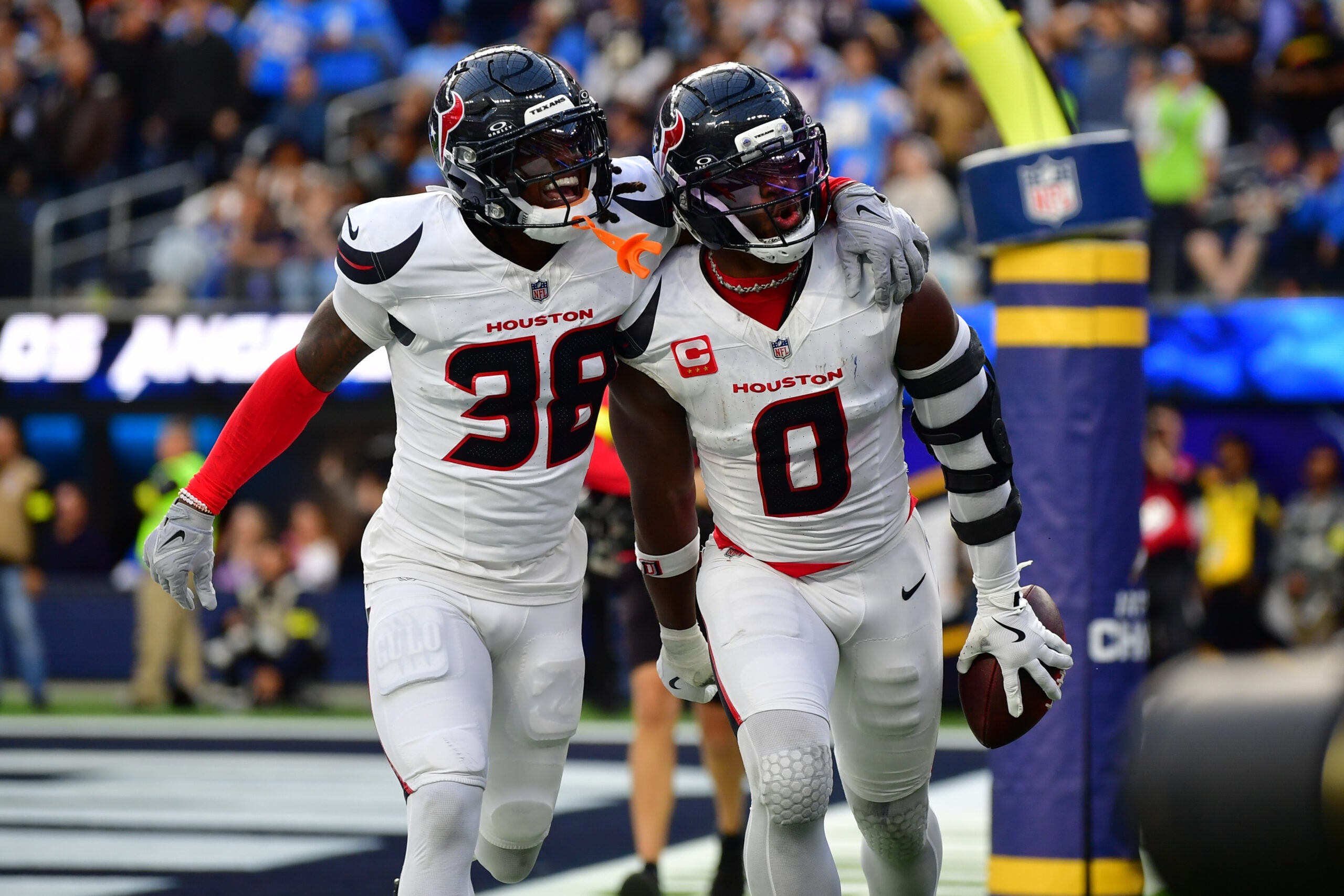 Dec 27, 2025; Inglewood, California, USA; Houston Texans linebacker Azeez al-Shaair (0) reacts with safety K'Von Wallace (38) after making an interception against the Los Angeles Chargers during the first half at SoFi Stadium.