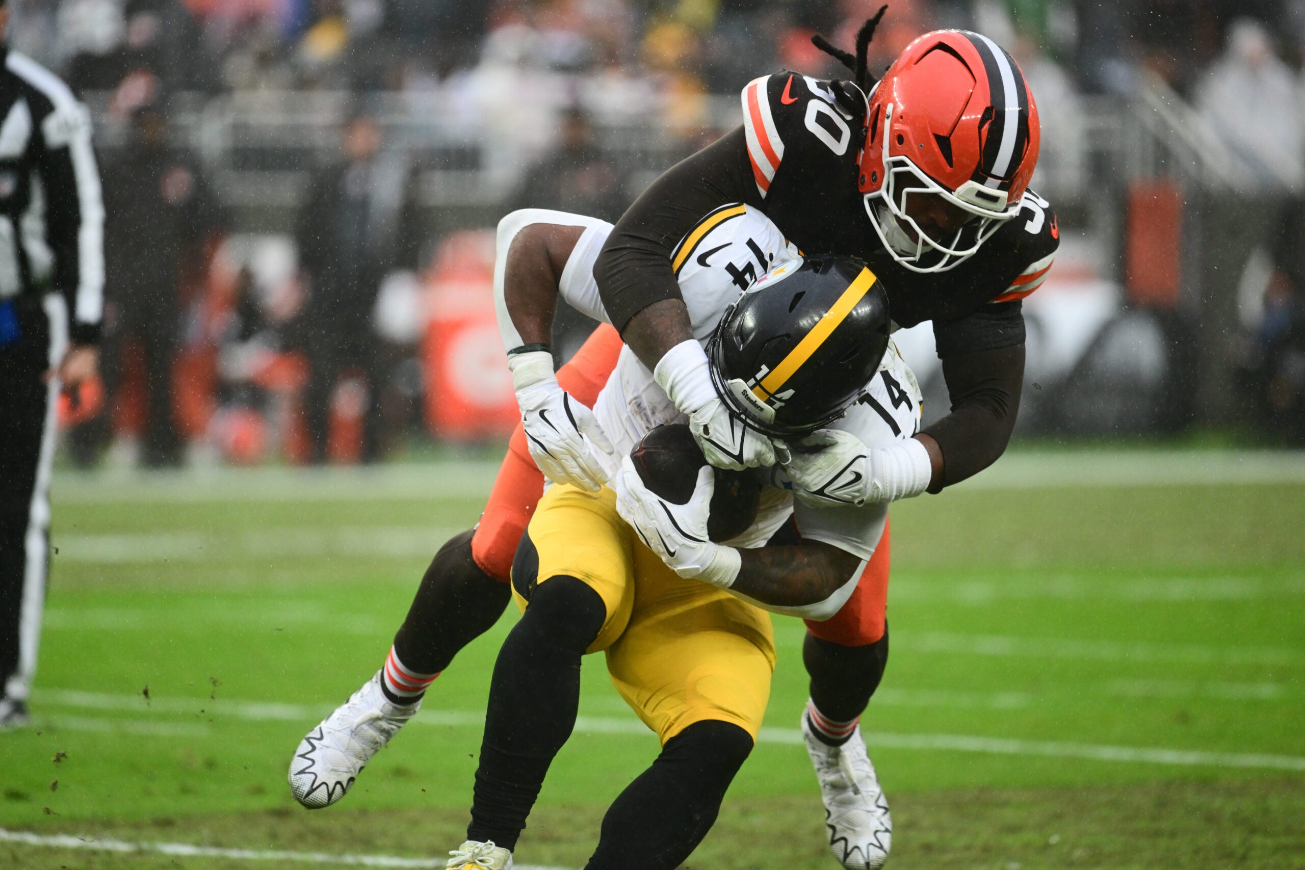 Dec 28, 2025; Cleveland, Ohio, USA; Cleveland Browns linebacker Devin Bush (30) tackles Pittsburgh Steelers running back Kenneth Gainwell (14) in the first quarter at Huntington Bank Field.