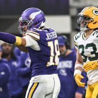 Jan 4, 2026; Minneapolis, Minnesota, USA; Minnesota Vikings wide receiver Justin Jefferson (18) celebrates after a play in front of Green Bay Packers safety Evan Williams (33) during the second quarter at U.S. Bank Stadium.
