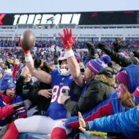 Bills tight end Dawson Knox leaps into the stands to celebrate with fans after scoring the opening touchdown of the game in first quarter against the Jets during the first half of their last regular season game at Highmark Stadium in Orchard Park Sunday, Jan. 4, 2026. The Bills won 35-8.